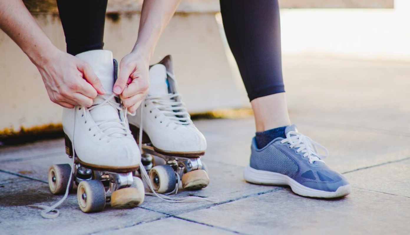 Uma pessoa amarrando o cadarço de um patins