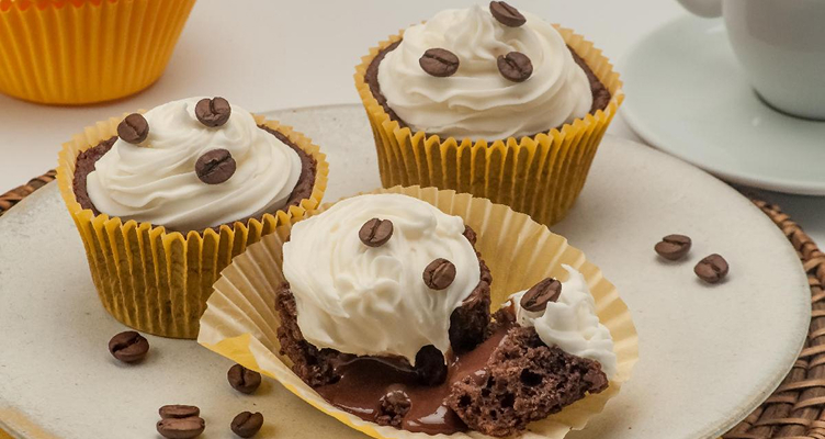 Imagem de um prato com cupcakes, grãos de café e uma xícara de café